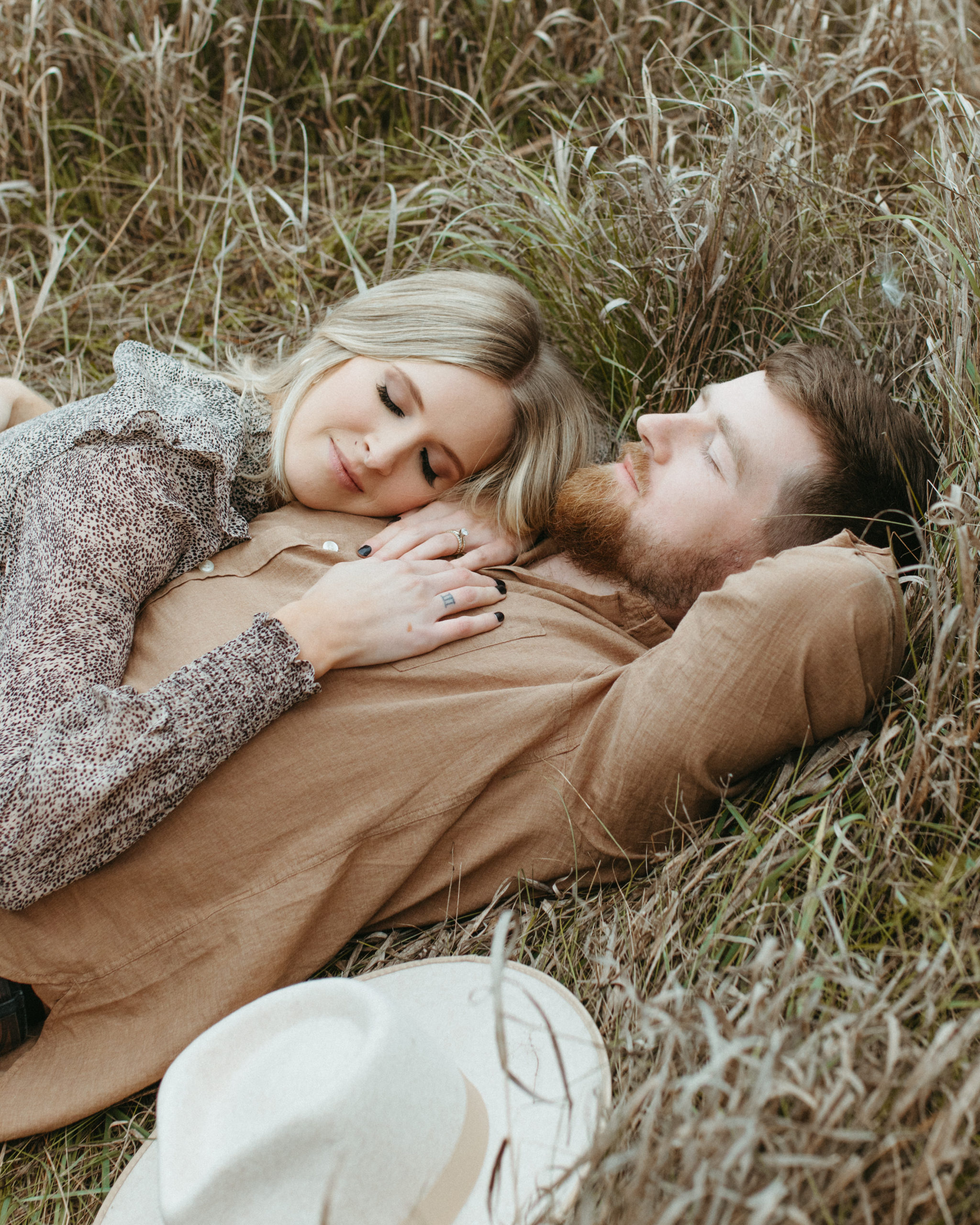 A couple lying in a field of grass.