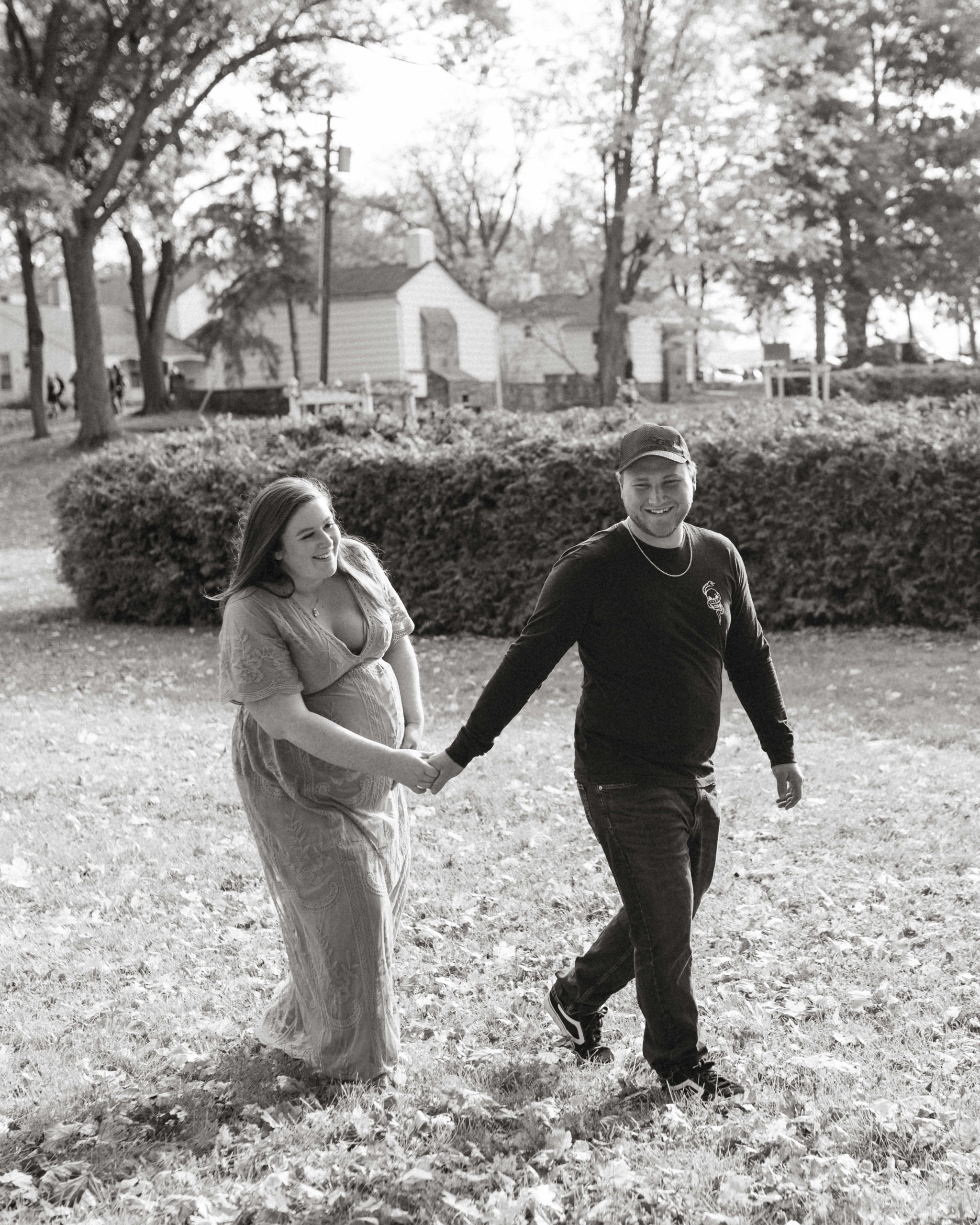 A black and white photo of a couple holding hands and walking.